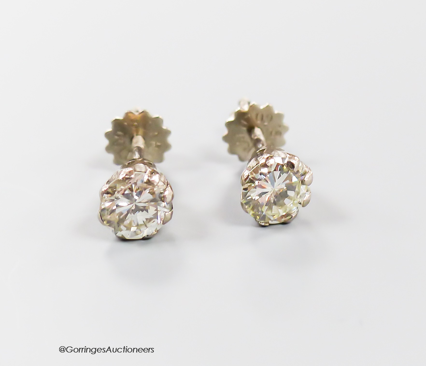 A modern pair of 18ct and solitaire diamond set ear studs, each stone weiging approximately 0.65ct-0.70ct, gross weight 2.2 grams.